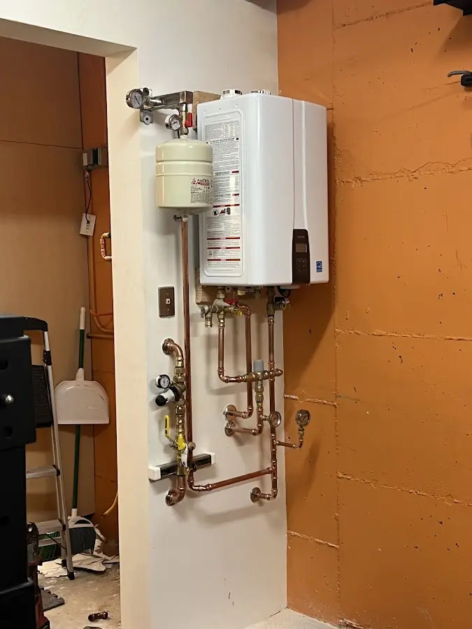 Plumbing technician inspecting water heater connections in Upper Darby
